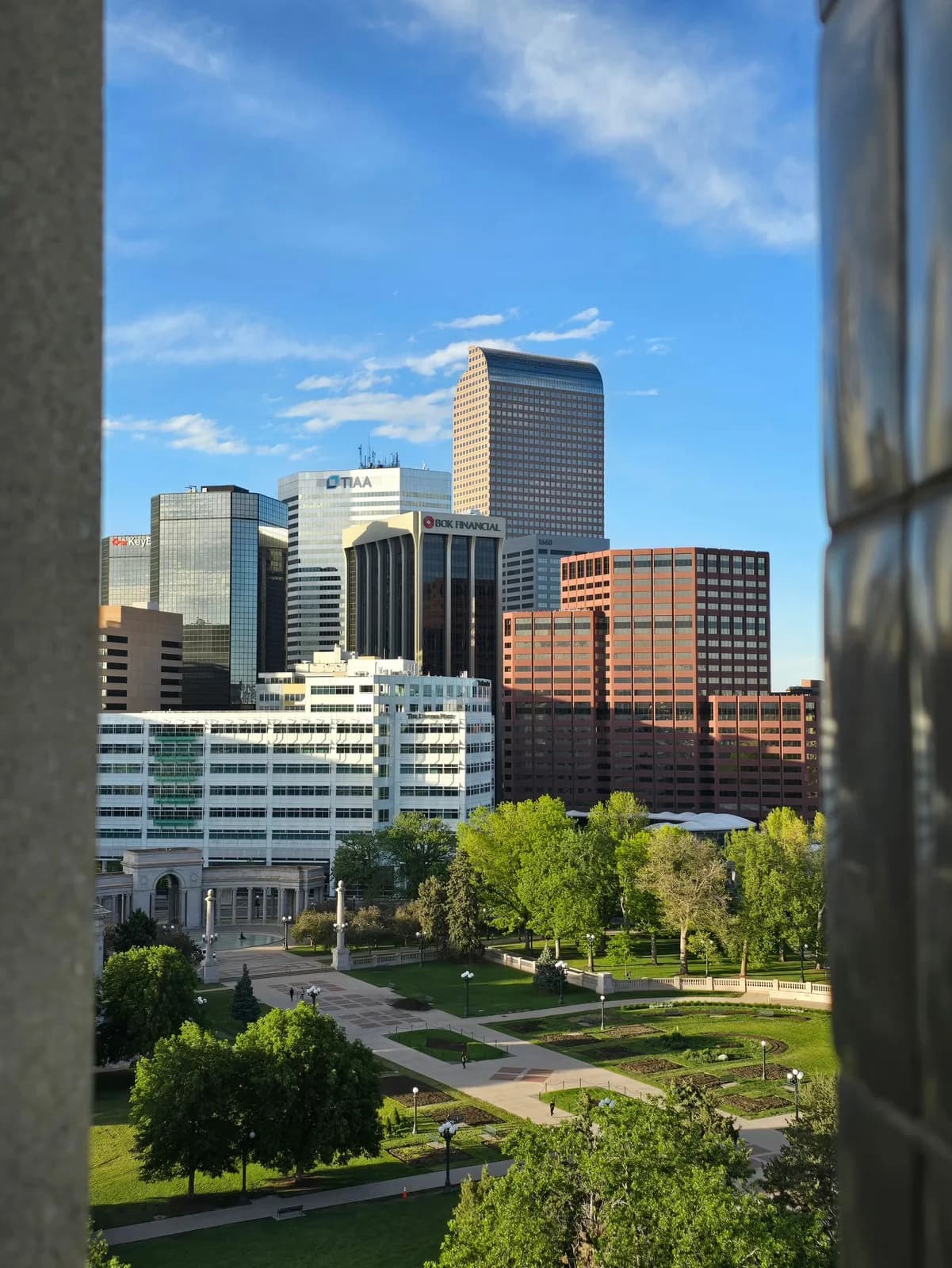 Downtown Denver skyline above green trees